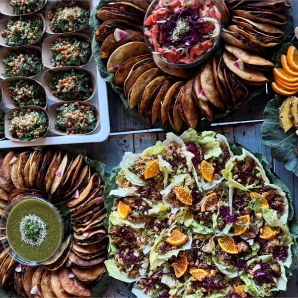 A vibrant spread of healthy Strive Foods dishes, including tacos, salads, and kale bowls.